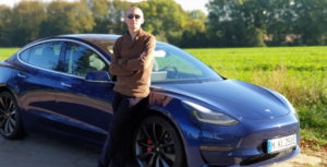 Blue Tesla Model 3 Performance against a field of green